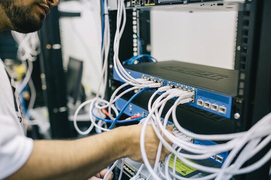 Un técnico manipulando cableado en un rack.