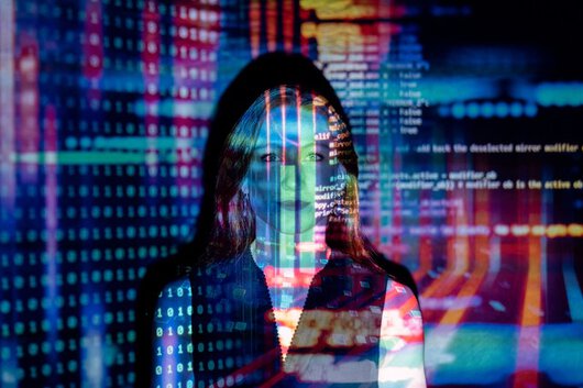 La imagen de código informático se refleja en el torso de una mujer.